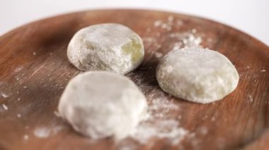 Dönüşümlü yeşil kibrit mochi, geleneksel Japon tatlısı, ahşap bir tabakta servis edilir. Yüksek kalite 4k görüntü