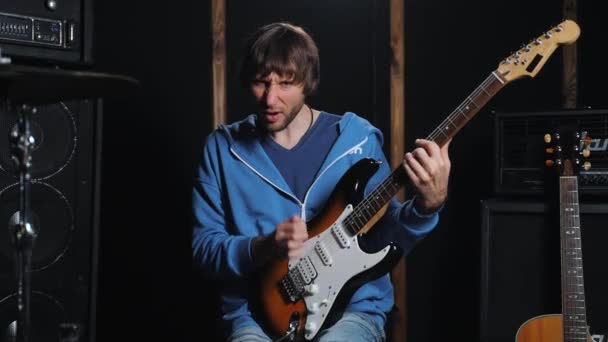 기타리스트는 스튜디오 리허설 공간에서 기타를 열정적으로 연주합니다 고품질 로열티 프리 스톡 푸티지