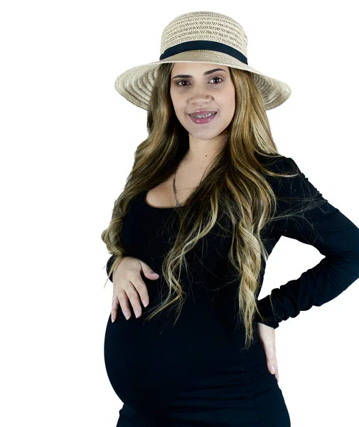怀孕的女人戴着草帽 穿着黑色衣服 对着摄像机微笑 那姑娘是白人出身 — 图库照片