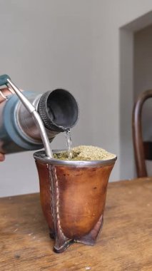 Geleneksel eş deri bir su kabağında taze yerba ile servis edilirken, sıcak su metal bir termostan dökülüyor. Güney Amerika kültür ritüeli, sıcaklık, lezzet ve özgünlük..
