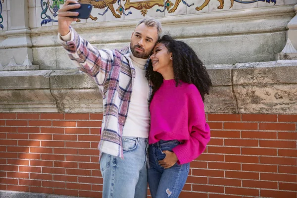 Genç çift parkta sarılıp selfie çekiyorlardı. Yüksek kalite fotoğraf