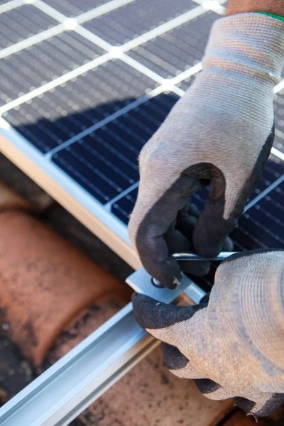 Close up of man technician in work gloves installing stand-alone photovoltaic solar panel