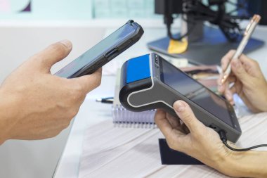 NFC teknolojisi kullanarak akıllı telefonunu ödeyen bir müşterinin yakın plan fotoğrafı. Müşteri için kart okuyucu makinesi. Bağlantı kurulamayan yöntemle ödeme işlemi yapıyor. - Evet. Yüksek kalite fotoğraf