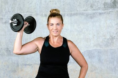 Atletik pozisyondaki bir kadının ağırlık kaldırma egzersizi. Yüksek kalite fotoğraf