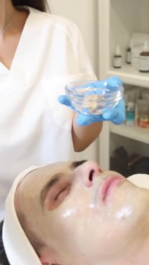 Yetenekli bir profesyonel, sakin bir spa ortamında müşterinin yüzüne yatıştırıcı bir tedavi uygular. Atmosfer sakin, yumuşak müzik rahatlama deneyimini arttırıyor..