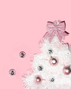 Noel ağacı ve pastel açık pembe arka plandaki süsler. Minimalist Yeni Yıl konsepti. Noel yatağı. Yaratıcı Xmas bileşimi.