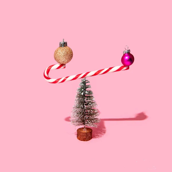 Christmas Baubles Balancing Candy Cane Pastel Light Pink Background Minimalistic — Stock Photo, Image
