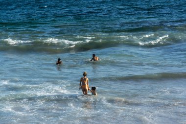 Salvador, Bahia, Brezilya - 22 Ekim 2022: İnsanlar Salvador, Bahia 'daki Farol da Barra plajında yüzüyorlar.