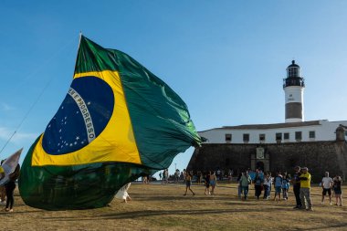 Salvador, Bahia, Brezilya - 22 Ekim 2022: Brezilya Cumhurbaşkanı Jair Bolsonaro 'nun destekçileri, Salvador, Bahia' daki Farol da Barra meydanına büyük bir Brezilya bayrağı dikti..