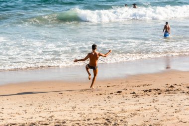 Salvador, Bahia, Brezilya - 22 Ekim 2022: Bir adam Brezilya 'nın Salvador kentindeki Farol da Barra plajında yoga yapıyor..