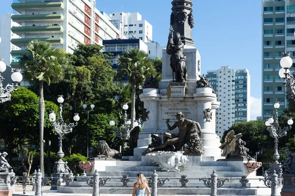 stock image Salvador, Bahia, Brazil - April 09, 2022: Woman walks near Salvador tourist spot. The monument of the heroes of the struggles for the Independence of Bahia, Brazil.