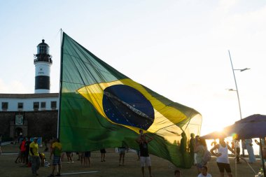 Salvador, Bahia, Brezilya - 22 Ekim 2022: Brezilya Cumhurbaşkanı Jair Bolsonaro 'nun destekçileri, Salvador, Bahia' daki Farol da Barra meydanına büyük bir Brezilya bayrağı dikti..