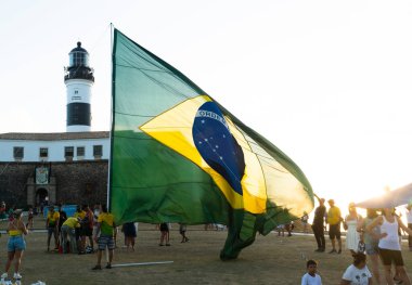 Salvador, Bahia, Brezilya - 22 Ekim 2022: Brezilya Cumhurbaşkanı Jair Bolsonaro 'nun destekçileri, Salvador, Bahia' daki Farol da Barra meydanına büyük bir Brezilya bayrağı dikti..
