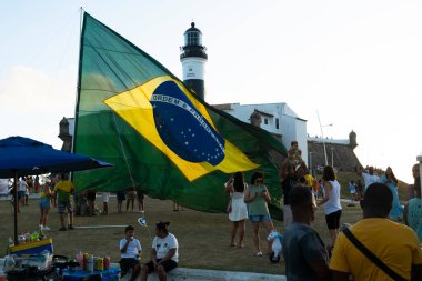 Salvador, Bahia, Brezilya - 22 Ekim 2022: Brezilya Cumhurbaşkanı Jair Bolsonaro 'nun destekçileri, Salvador, Bahia' daki Farol da Barra meydanına büyük bir Brezilya bayrağı dikti..