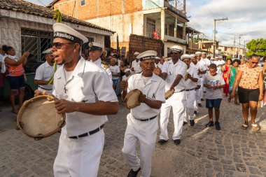 Saubara, Bahia, Brezilya - 06 Ağustos 2022: Encontro de Chegancas kültür grubu üyeleri beyaz kıyafetler giyer ve perküsyon enstrümanları çalarlar. Saubara, Bahia.