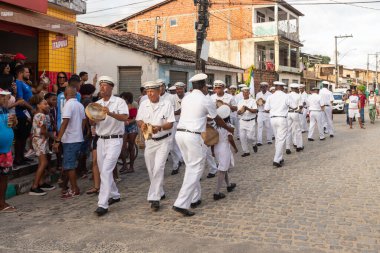 Saubara, Bahia, Brezilya - 06 Ağustos 2022: Encontro de Chegancas kültür grubu üyeleri beyaz kıyafetler giyer ve perküsyon enstrümanları çalarlar. Saubara, Bahia.