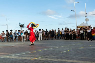 Salvador, Bahia, Brezilya - 22 Ekim 2022: Brezilya, Salvador 'da Farol da Barra meydanında sokak dansı yapan bir dansçı.