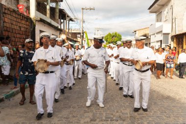 Saubara, Bahia, Brezilya - 06 Ağustos 2022: Encontro de Chegancas kültür grubu üyeleri beyaz kıyafetler giyer ve perküsyon enstrümanları çalarlar. Saubara, Bahia.