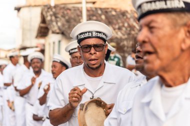 Saubara, Bahia, Brezilya - 06 Ağustos 2022: Encontro de Chegancas kültür grubu üyeleri beyaz kıyafetler giyer ve perküsyon enstrümanları çalarlar. Saubara, Bahia.