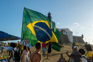 Salvador, Bahia, Brezilya - 22 Ekim 2022: Brezilya Cumhurbaşkanı Jair Bolsonaro 'nun destekçileri, Salvador, Bahia' daki Farol da Barra meydanına büyük bir Brezilya bayrağı dikti..