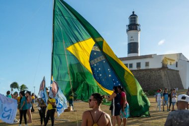 Salvador, Bahia, Brezilya - 22 Ekim 2022: Brezilya Cumhurbaşkanı Jair Bolsonaro 'nun destekçileri, Salvador, Bahia' daki Farol da Barra meydanına büyük bir Brezilya bayrağı dikti..