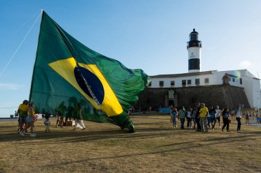Salvador, Bahia, Brezilya - 22 Ekim 2022: Brezilya Cumhurbaşkanı Jair Bolsonaro 'nun destekçileri, Salvador, Bahia' daki Farol da Barra meydanına büyük bir Brezilya bayrağı dikti..