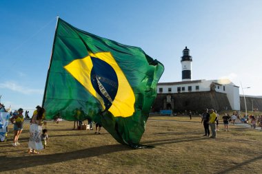 Salvador, Bahia, Brezilya - 22 Ekim 2022: Brezilya Cumhurbaşkanı Jair Bolsonaro 'nun destekçileri, Salvador, Bahia' daki Farol da Barra meydanına büyük bir Brezilya bayrağı dikti..