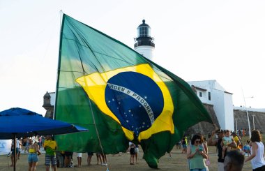 Salvador, Bahia, Brezilya - 22 Ekim 2022: Brezilya Cumhurbaşkanı Jair Bolsonaro 'nun destekçileri, Salvador, Bahia' daki Farol da Barra meydanına büyük bir Brezilya bayrağı dikti..