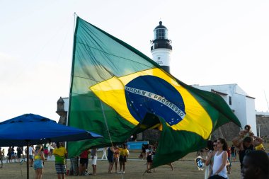 Salvador, Bahia, Brezilya - 22 Ekim 2022: Brezilya Cumhurbaşkanı Jair Bolsonaro 'nun destekçileri, Salvador, Bahia' daki Farol da Barra meydanına büyük bir Brezilya bayrağı dikti..