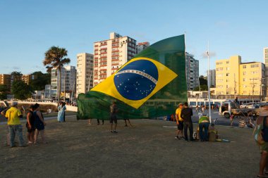 Salvador, Bahia, Brezilya - 22 Ekim 2022: Brezilya Cumhurbaşkanı Jair Bolsonaro 'nun destekçileri, Salvador' daki Farol da Barra Meydanı 'na büyük bir Brezilya bayrağı dikerek protesto etti..