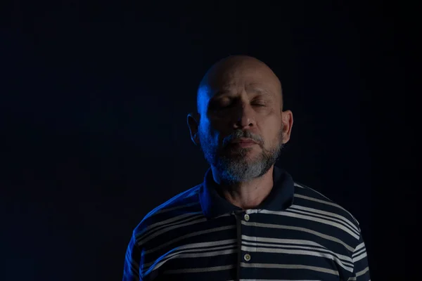 Young handsome bald man with beard wearing casual shirt over black background. Thinking worried. Thoughtful.
