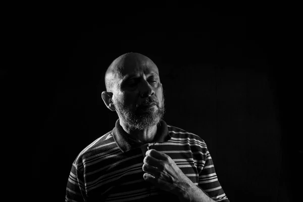 Handsome bald mature man with beard, wearing casual shirt. Black and white portrait. Thinking worried. Considered.