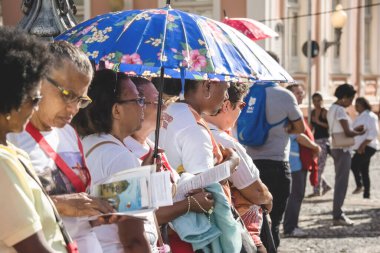 Salvador, Bahia, Brezilya - 26 Mayıs 2016: Şemsiyeli Katolik inananlar, Salvador, Bahia 'daki Corpus Christ ayini sırasında dua ediyorlar.