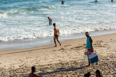 Salvador, Bahia, Brezilya - 22 Ekim 2022: Bir bahar günü Brezilya 'nın Salvador kentindeki Farol da Barra plajına insanlar giriyor.