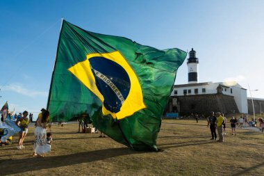 Salvador, Bahia, Brezilya - 22 Ekim 2022: Brezilya Cumhurbaşkanı Jair Bolsonaro 'nun destekçileri, Salvador, Bahia' daki Farol da Barra meydanına büyük bir Brezilya bayrağı dikti..
