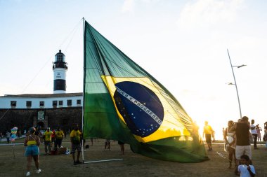 Salvador, Bahia, Brezilya - 22 Ekim 2022: Brezilya Cumhurbaşkanı Jair Bolsonaro 'nun destekçileri, Salvador, Bahia' daki Farol da Barra meydanına büyük bir Brezilya bayrağı dikti..