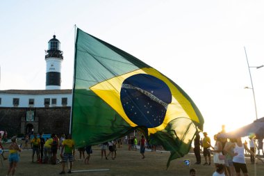 Salvador, Bahia, Brezilya - 22 Ekim 2022: Brezilya Cumhurbaşkanı Jair Bolsonaro 'nun destekçileri, Salvador, Bahia' daki Farol da Barra meydanına büyük bir Brezilya bayrağı dikti..