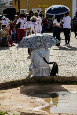 Salvador, Bahia, Brezilya - 26 Mayıs 2016: Brezilya 'nın Salvador kentindeki Corpus Christ ayini sırasında Katolik bir keşiş sokakta oturuyor.