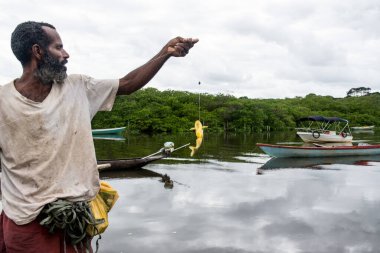 Aratuipe, Bahia, Brezilya - 31 Ağustos 2018: Balıkçı oltaya takılmış balıklarla olta atıyor. Aratuipe, Bahia, Brezilya.