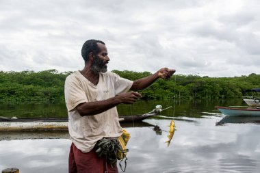 Aratuipe, Bahia, Brezilya - 31 Ağustos 2018: Balıkçı oltaya takılmış balıklarla olta atıyor. Aratuipe, Bahia, Brezilya.