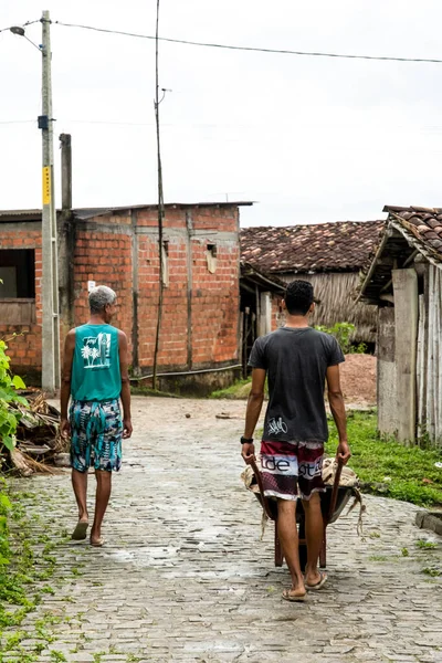 Aratuipe, Bahia, Brezilya - 31 Ağustos 2018: Aratuipe, Bahia sokaklarından geçerek mağazaya mal taşıyan iki işçi.