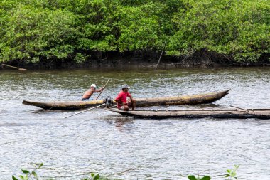 Aratuipe, Bahia, Brezilya - 31 Ağustos 2018: Her biri kanolarında sabah güneşinde Jaguaripe Nehri 'nde yelken açan iki balıkçı.