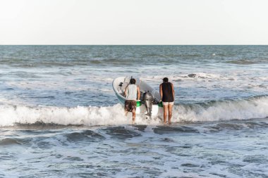 Valenca, Bahia, Brezilya - 10 Eylül 2022: Bir motorlu tekneyle denize giren iki adam. Guaibim Plajı, Valenca, Bahia.