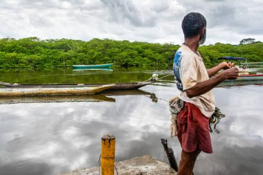 Aratuipe, Bahia, Brezilya - 31 Ağustos 2018: Balıkçı, Bahia 'nın Aratuipe kentindeki Jaguaripe nehrinin kıyısında balık yakalamak için yem atıyor.