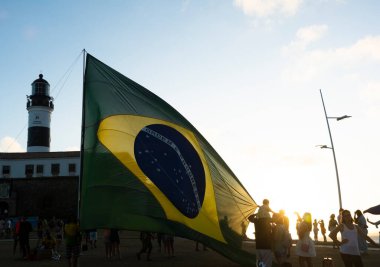 Salvador, Bahia, Brezilya - 22 Ekim 2022: Brezilya Cumhurbaşkanı Jair Bolsonaro 'nun destekçileri, Salvador, Bahia' daki Farol da Barra meydanına büyük bir Brezilya bayrağı dikti..