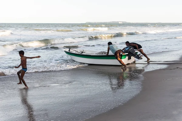 Stock image Valenca, Bahia, Brazil - September 10, 2022: People pushing a boat into the sea. Guaibim Beach, city of Valenca, Bahia.