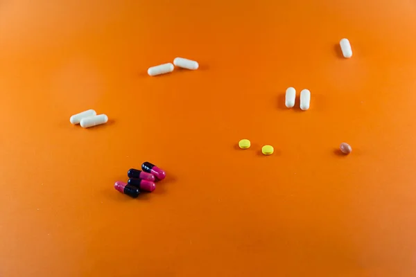 Různé Pilulky Roztroušené Oranžovém Pozadí Zdravotnické Potřeby — Stock fotografie