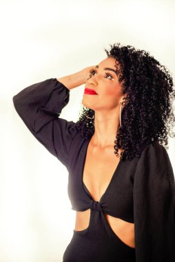 Eli saçında, gülümseyen genç bir kadın. Yukarı bakıyorum. Stüdyoda beyaz arka planda izole edilmiş.