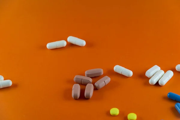 Různé Pilulky Hnědé Bílé Modré Žluté Barvy Rozptýlené Oranžovém Pozadí — Stock fotografie