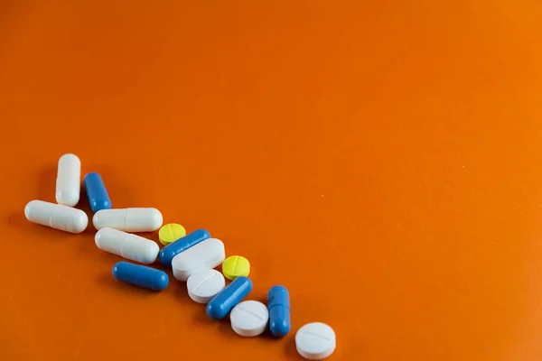 Naskládané Pilulky Oranžovém Pozadí Zdravotnické Potřeby — Stock fotografie